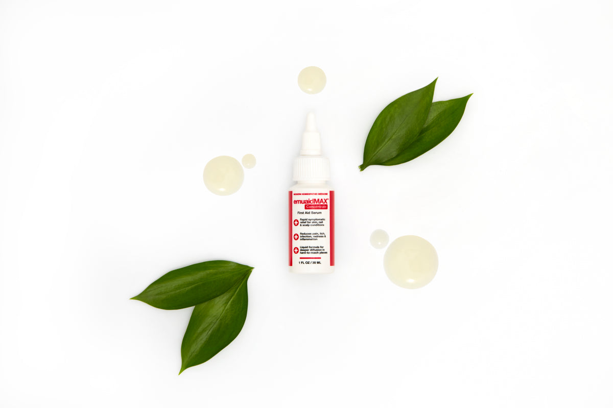 Sérum emuaidmax avec des feuilles vertes sur fond blanc