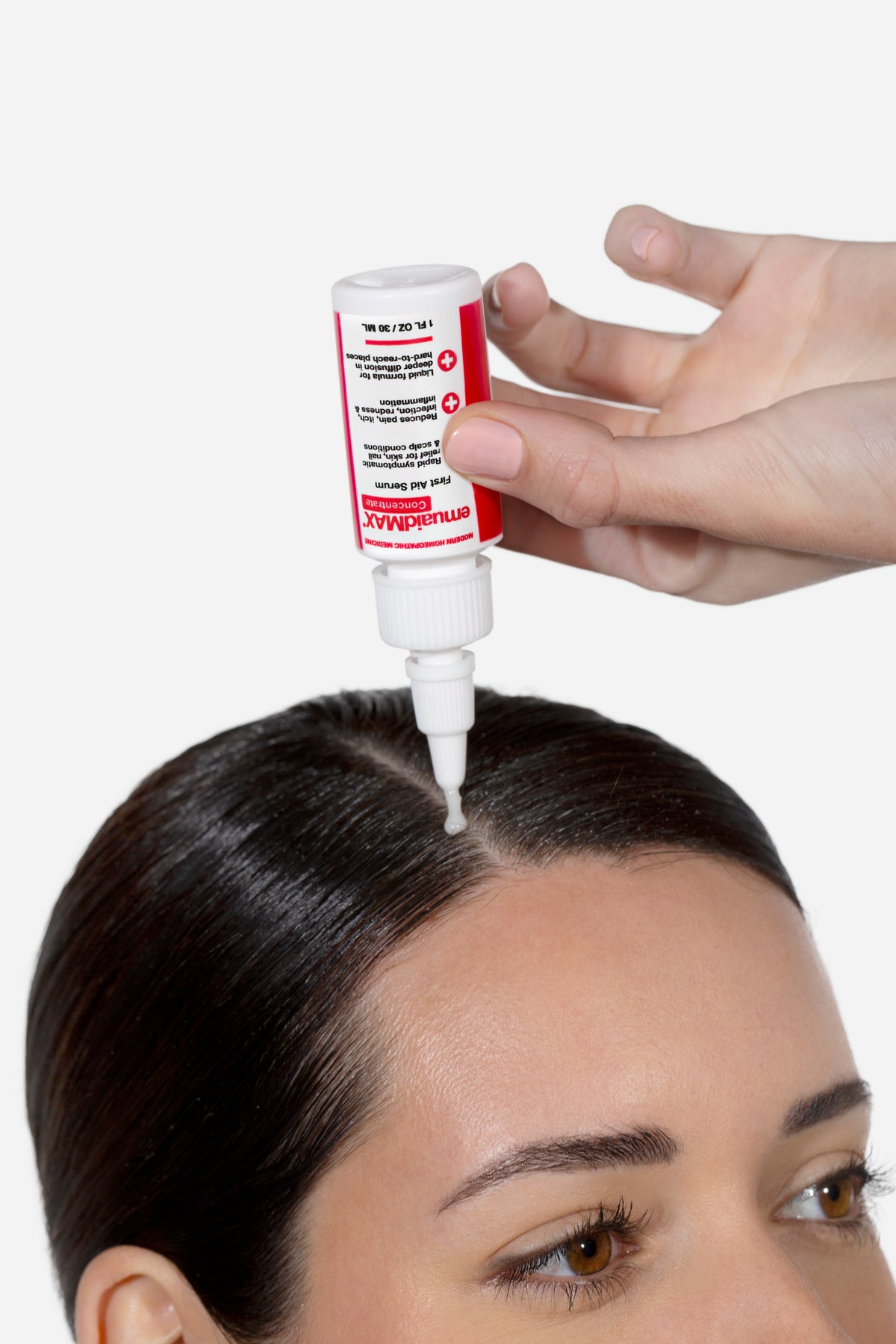 Une personne appliquant le sérum emuaidmax sur sa racine des cheveux