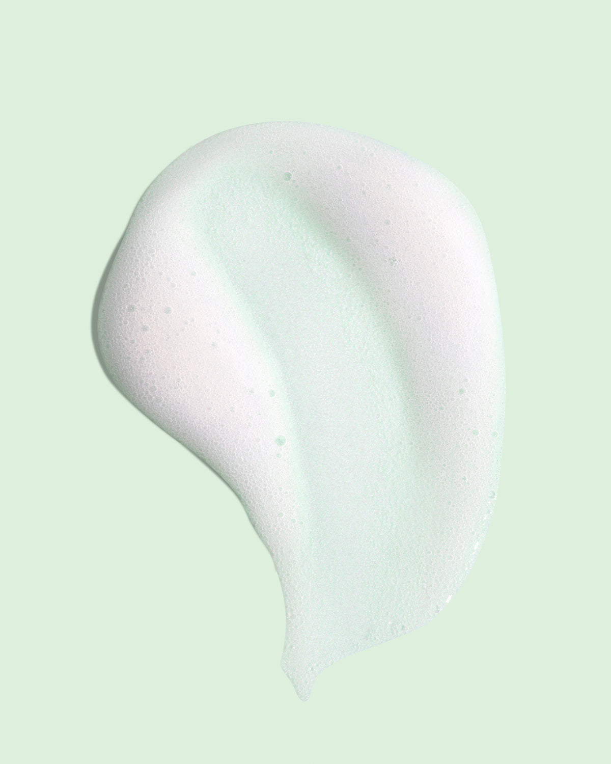 Primo piano di una macchia color crema su sfondo verde