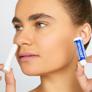 This is a picture of a woman using the EMUAID® First Defense Inhaler.